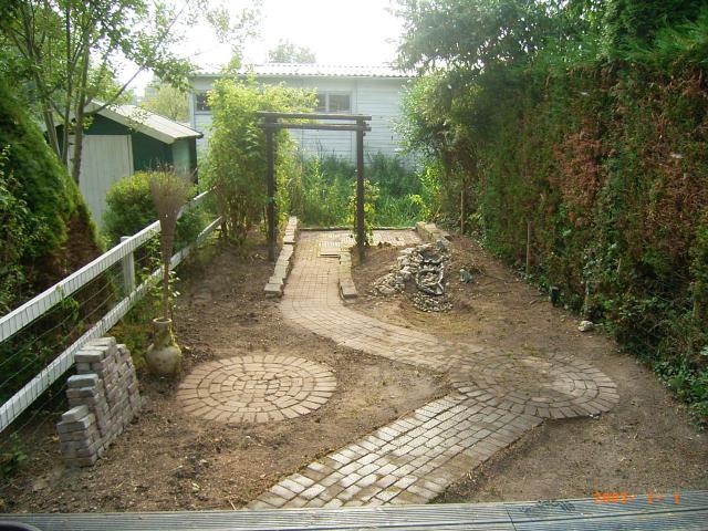 diepe tuin grenzend aan sloot met sierbestrating